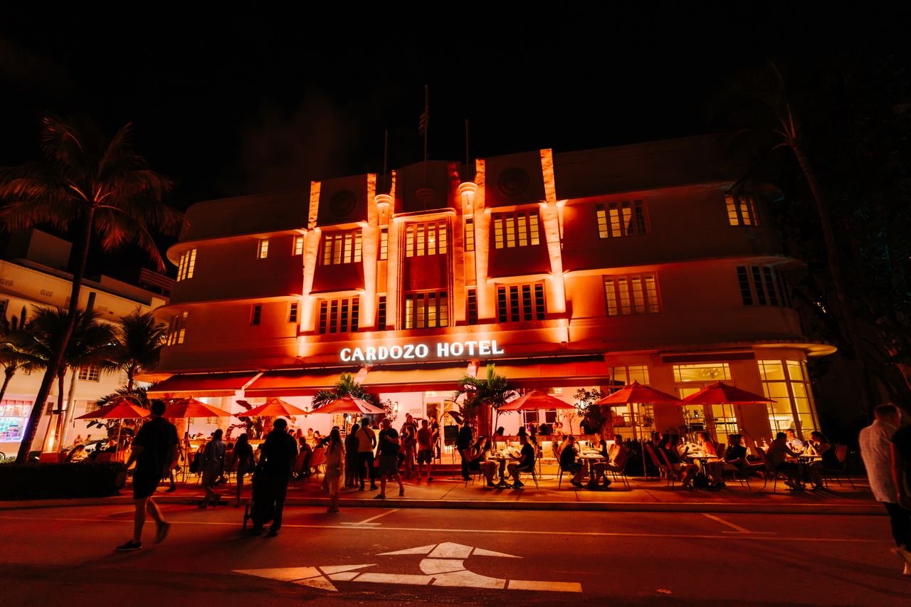 The Art of Drawing Readers In: Your attractive post title goes here Illuminated Cardozo Hotel with lively nightlife scene on a bustling street.