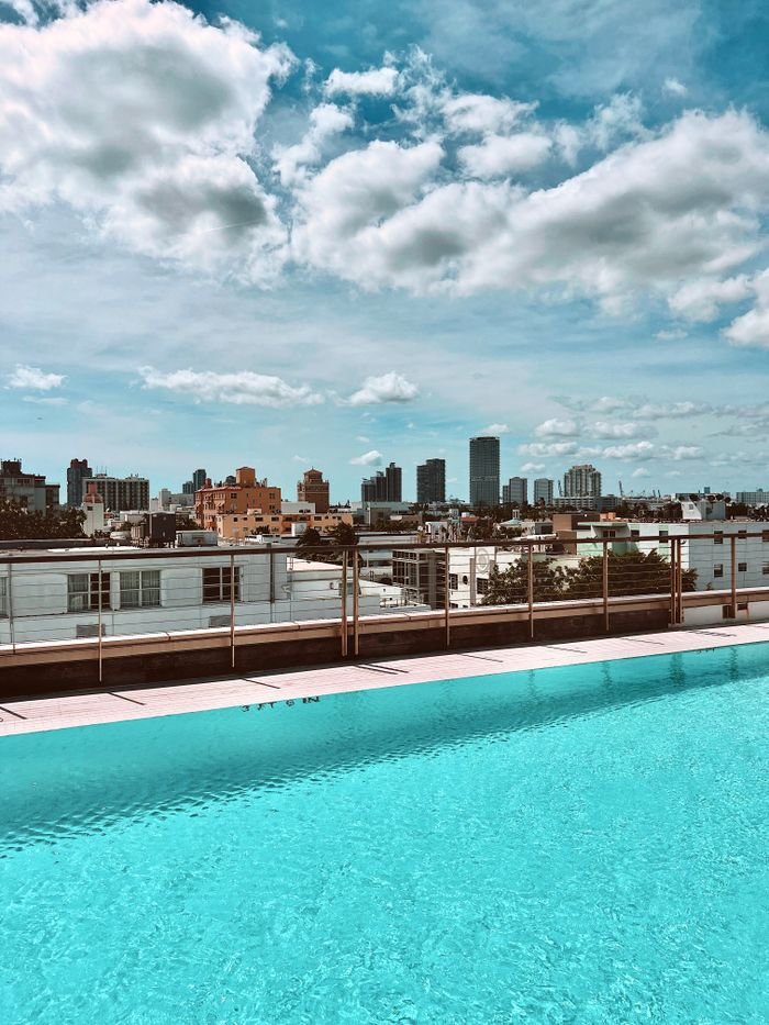 Mastering the First Impression: Your intriguing post title goes here A rooftop pool with a stunning city skyline view under a blue sky.